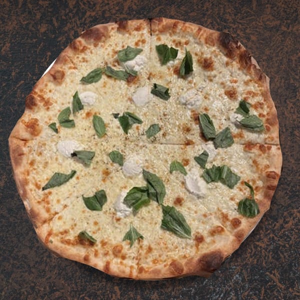 Whole white pizza with ricotta cheese dollops and fresh basil leaves on a dark surface.