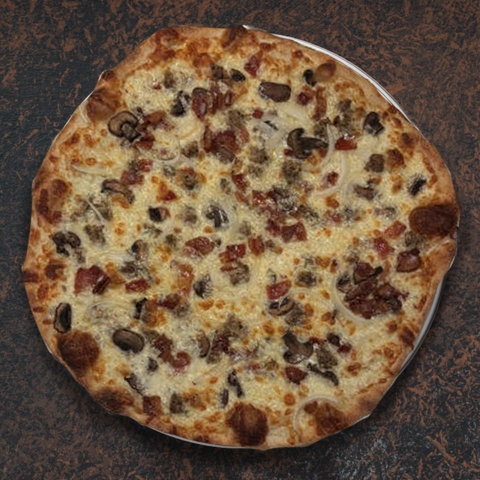 A whole pizza with white sauce, cheese, mushrooms, sausage, bacon, and onions on a dark surface.