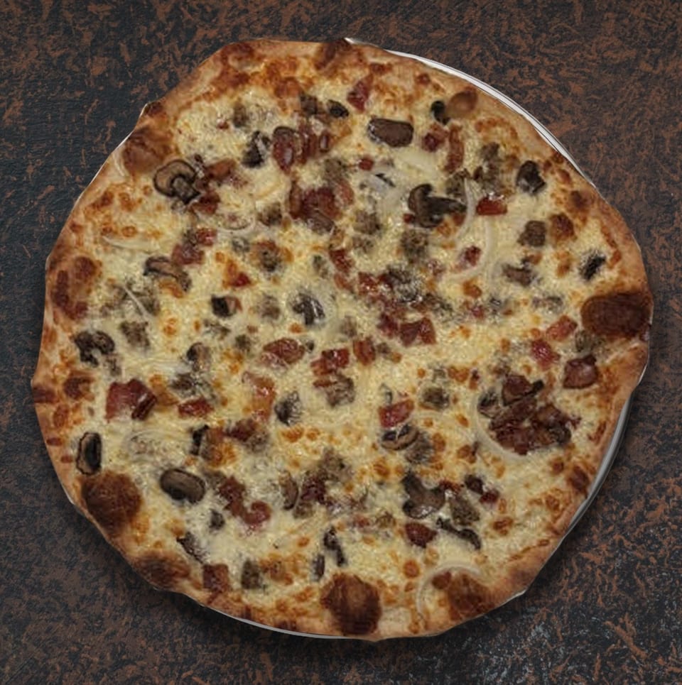 A whole pizza with white sauce, cheese, mushrooms, sausage, bacon, and onions on a dark surface.