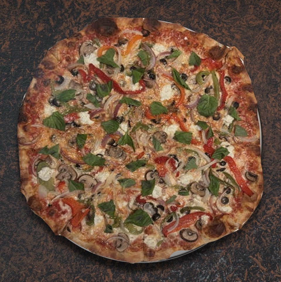 A whole vegetarian pizza with mushrooms, peppers, onions, olives, and basil on a dark surface.